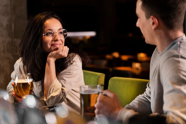 クローズアップの笑顔の女性とビールと男性