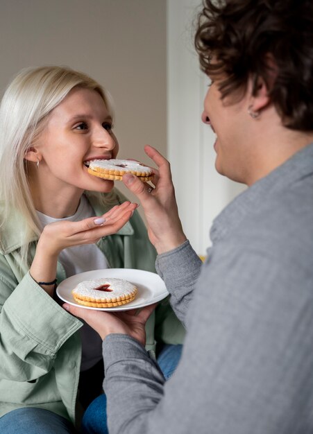 Close up smiley woman eating cookie