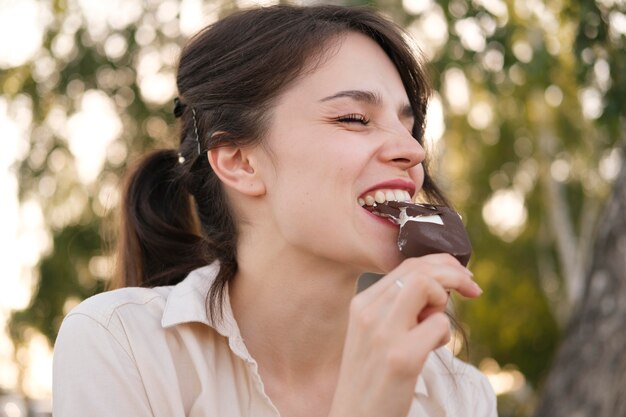 アイスクリームを食べる笑顔の女性をクローズアップ