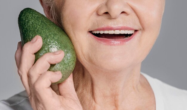 Close-up smiley woman holding avocado