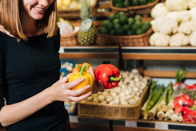 Close-up smiley woman holding bell peppers