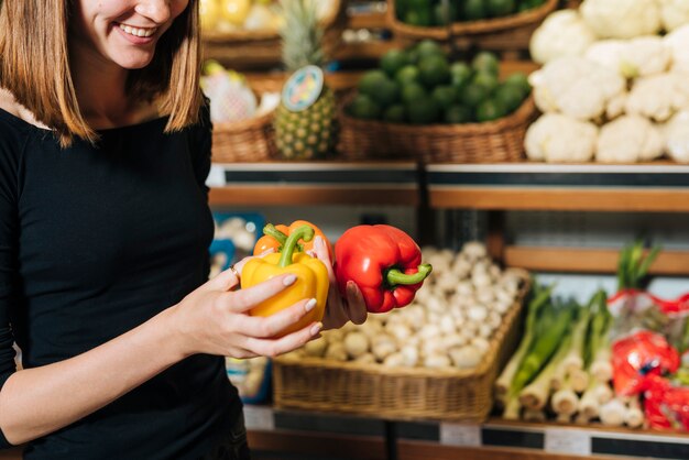 close-up smiley woman holding bell peppers