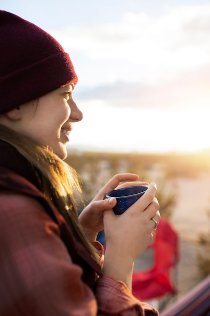 Foto gratuita chiuda sulla tazza della holding della donna di smiley