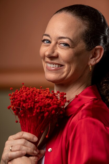 Close up smiley woman holding flowers