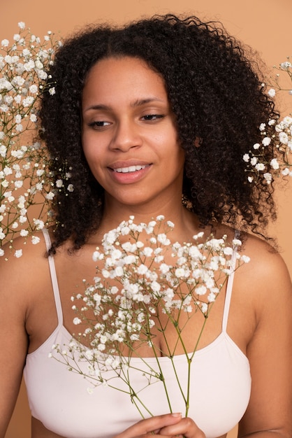 Close up smiley woman holding flowers