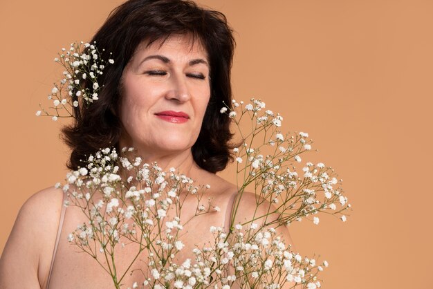 Close up smiley woman holding flowers