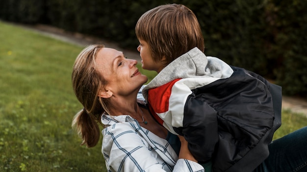 Foto gratuita bambino della holding della donna di smiley del primo piano