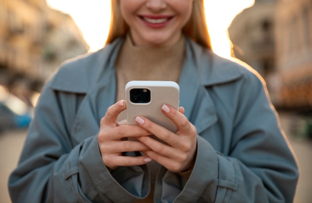 Foto gratuita close up donna sorridente che tiene il telefono