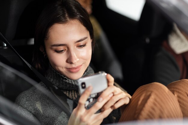 スマートフォンを持っている笑顔の女性を閉じる