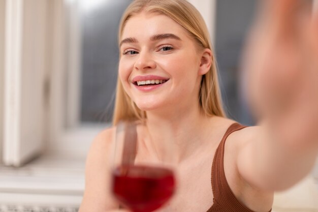 ワインを持っている笑顔の女性をクローズアップ