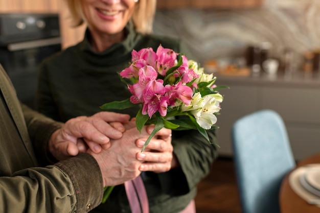 Free photo close up smiley woman receiving flowers
