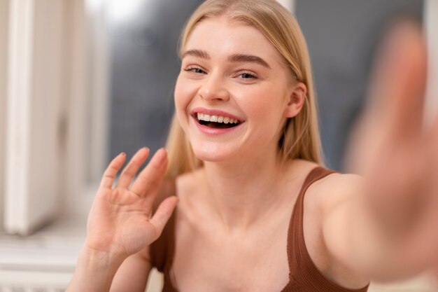 Close up smiley woman waving