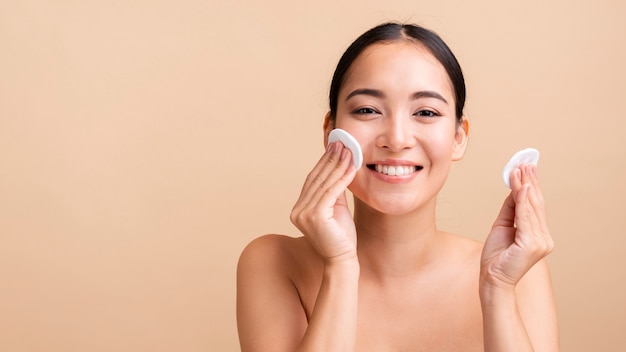 Close-up smiley woman with cotton pads and copy-space