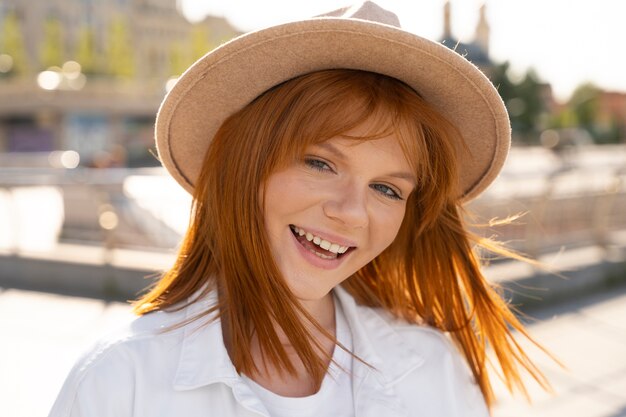 Close up smiley woman with hat in city