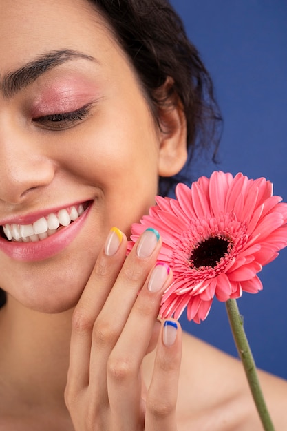 Крупным планом улыбающаяся женщина с розовым цветком