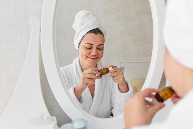 Close-up smiley woman with serum