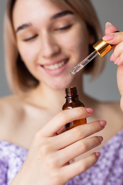 Close up smiley woman with serum