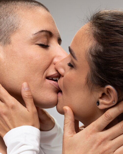 Close up smiley women kissing