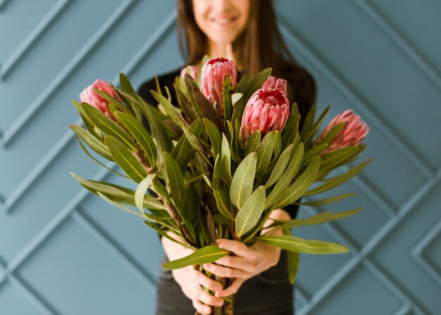 Close-up smiley young woman holding a bouquet