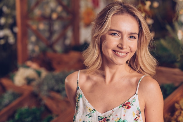 Free photo close-up of smiling blonde young woman in florist shop