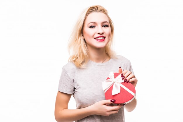 Close-up of smiling blondie woman holding heart shaped giftbox