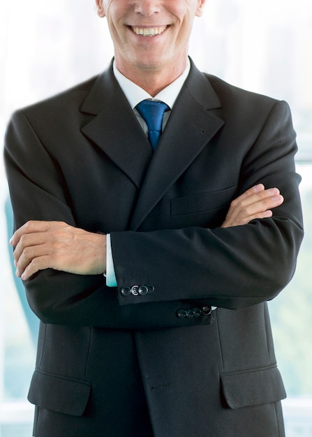 Free photo close-up of a smiling businessman with folded arms
