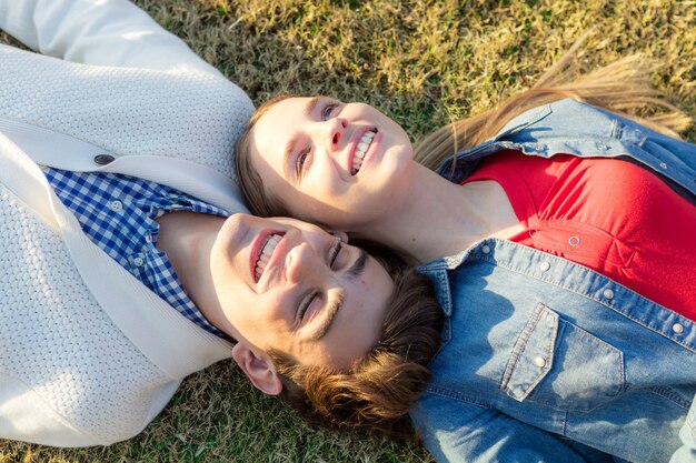 Close-up of smiling couple resting on grass