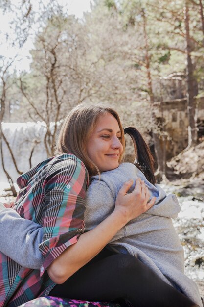 Close-up of smiling girl embracing her friend