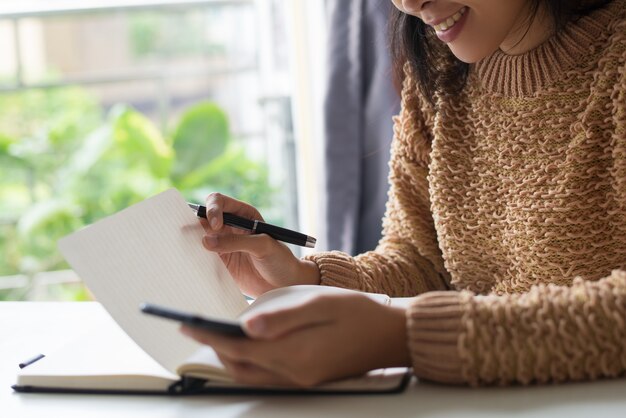 Close-up of smiling lady reading her notes in diary