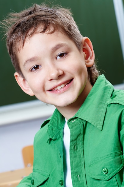 녹색 셔츠와 함께 웃는 어린 소년의 근접 촬영