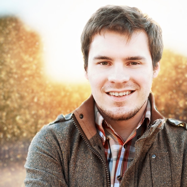 Foto gratuita primo piano di uomo sorridente in campo al tramonto