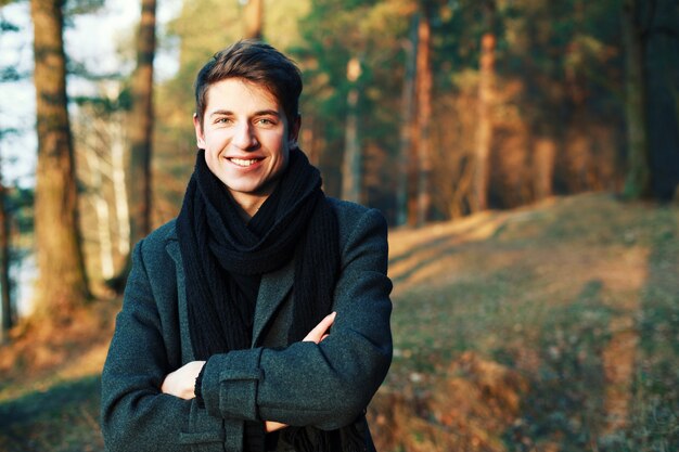 Close-up of smiling man with folded arms in the field