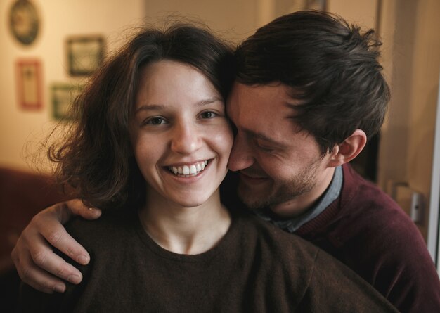 Close-up of smiling man with hand on his girlfriend's shoulder