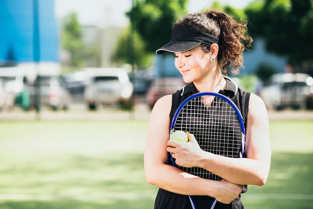 Close-up of a smiling tennis player holding racket