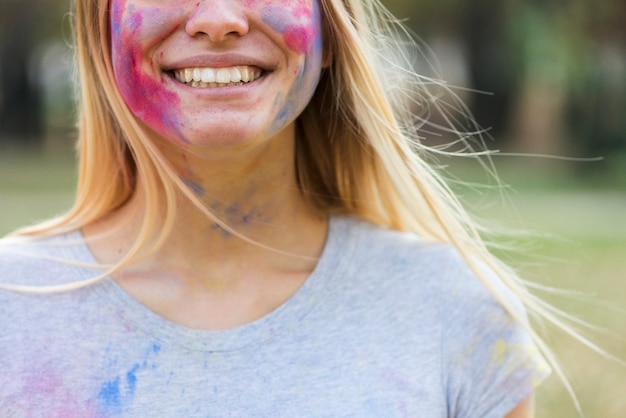 Close-up of smiling woman covered in colors