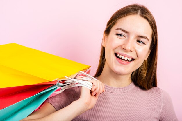 Close-up smiling woman holding bags