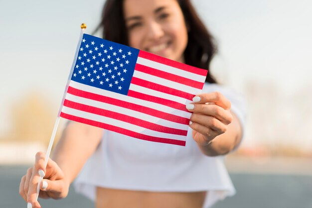 미국 국기를 들고 근접 웃는 여자