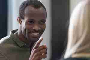 Free photo close up of a smiling young african man pointing finger