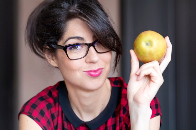 Close-up of smiling young woman with an apple