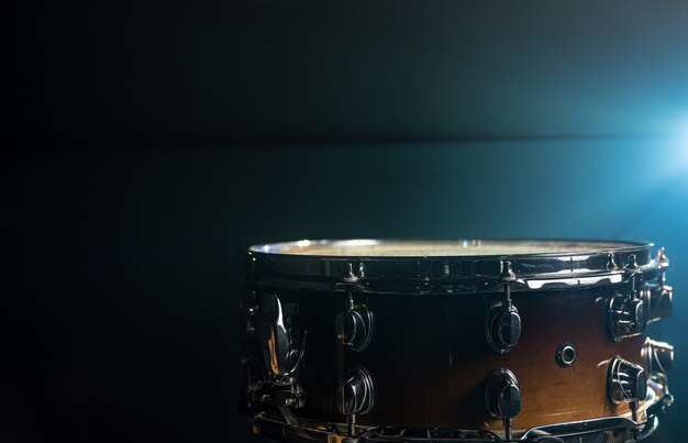 Close-up of a snare drum, percussion instrument on a dark background with beautiful lighting, copy space.