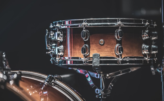 Close-up of a snare drum, percussion instrument on a dark background.