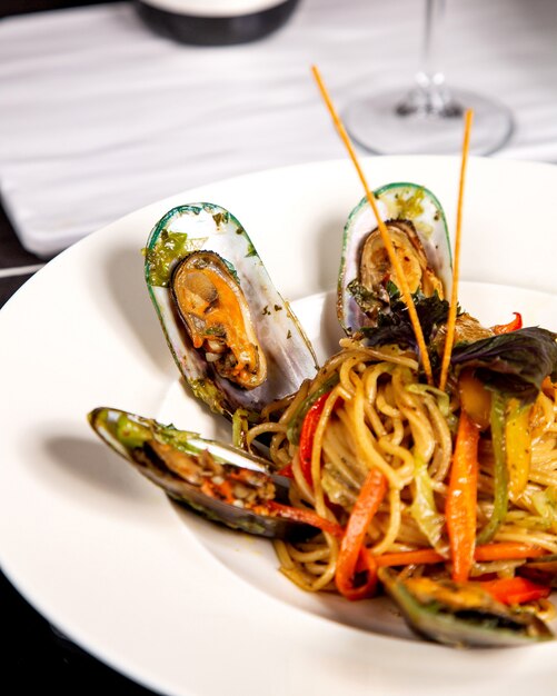 Close up of spaghetti with mussels and bell peppers