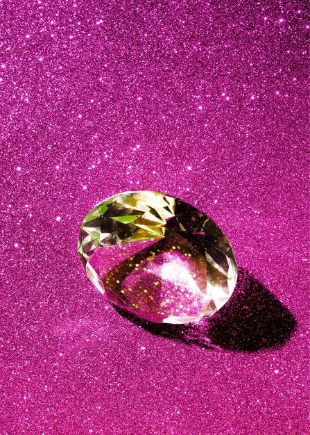 Close-up of a sparkling diamond on the pink shiny background