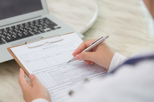 Close-up of specialist filling out a form