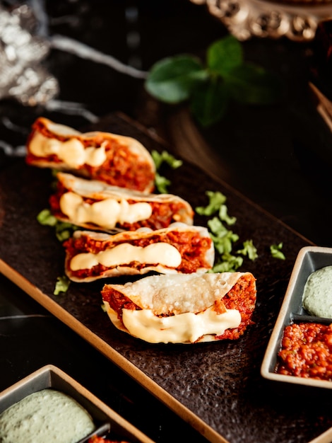 Close up of spicy mini tacos served with chili paste