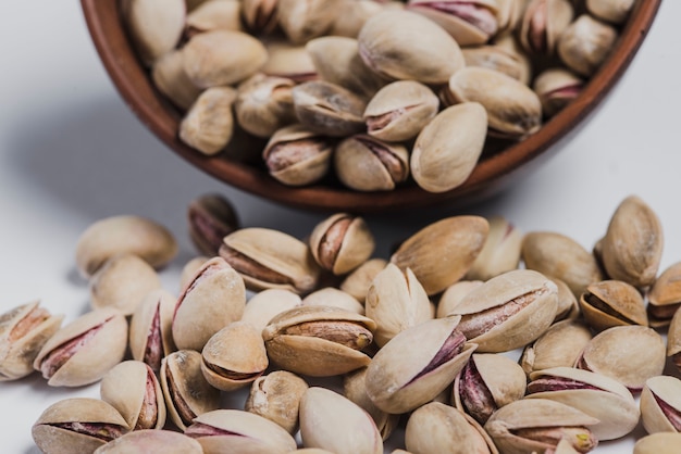 Close-up spilled pistachios and bowl