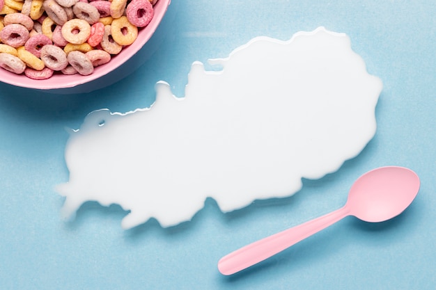 Free photo close-up splash of milk with pink bowl and spoon