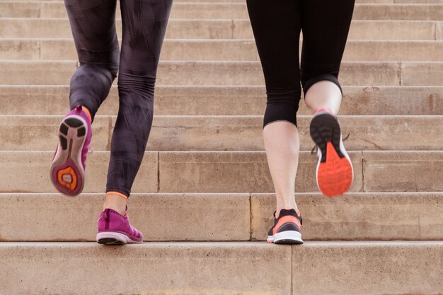 Close-up of sportswomen climbing stairs