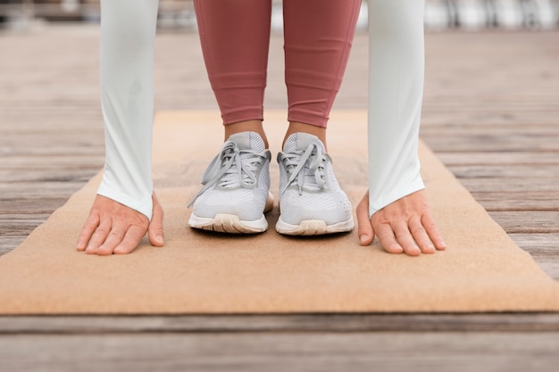 Foto gratuita chiuda sulla persona sportiva che fa yoga