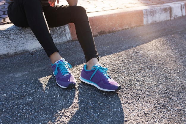 Крупный план спортивного женщина с фиолетовыми кроссовками